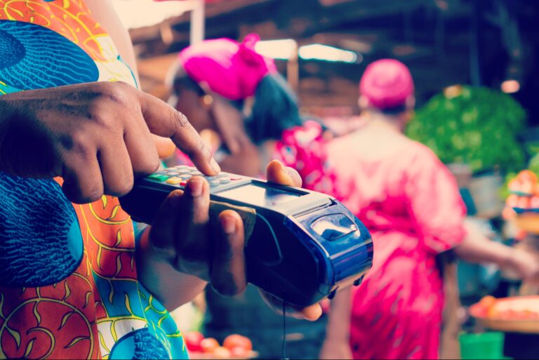 Ciemnoskóry człowiek wpisujący kod na terminalu płatniczym